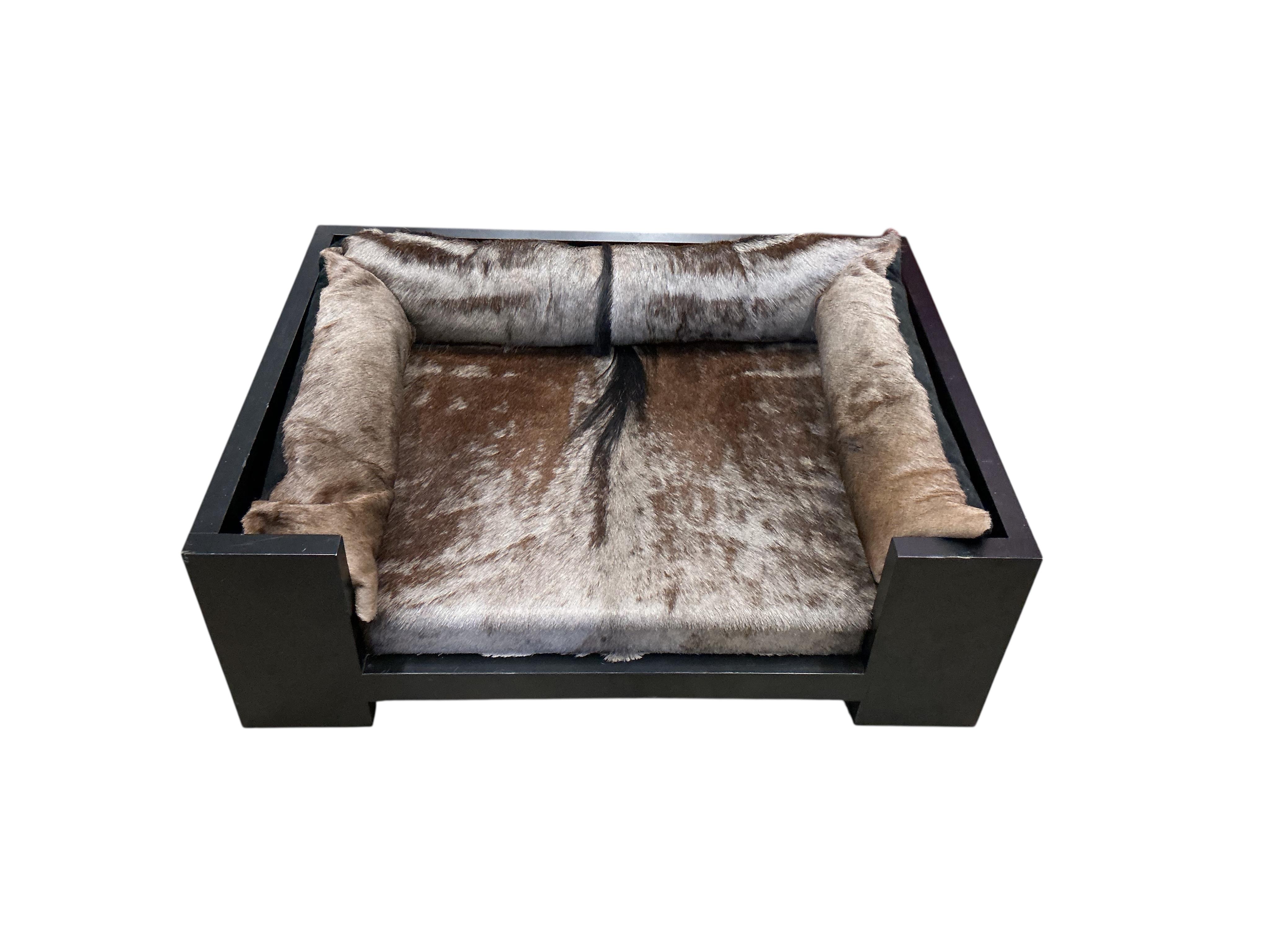 A contemporary ebonised dog bed with faux fur cushions, width 87cm, depth 67cm, height 29cm
